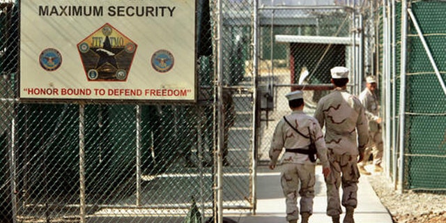 FILE - In this June 27, 2006 file photo, reviewed by a Defense Department, U.S. military guards walk within Camp Delta military-run prison, at the Guantanamo Bay U.S. Naval Base, Cuba. A federal appeals court expressed concerns on Thursday, Sept. 8, 2016, about the prospect of ordering the Obama administration to release graphic videos of a former Guantanamo Bay inmate being force-fed during a hunger strike. (AP Photo/Brennan Linsley, File)