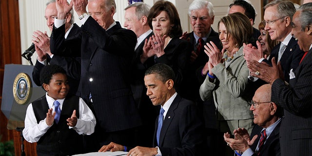 In this March 23, 2010, file photo President Barack Obama is applauded after signing the Affordable Care Act into law in the East Room of the White House in Washington.