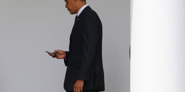 File photo - President Barack Obama checks his Blackberry smartphone.