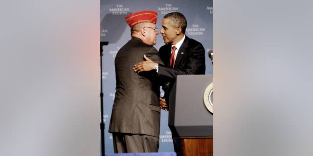 President Barack Obama, right, is greeted by Jimmie Foster, national commander of the American Legion prior to Obama's address to its national convention, Tuesday, Aug. 30, 2011, in Minneapolis. (AP Photo/Jim Mone)