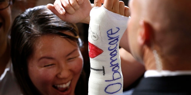 FILE: October 30, 2013: A Massachusetts woman after President Obama signed her cast in Boston, Mass.