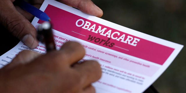 FILE: September 28, 2013. A man fills out an information card during an Affordable Care Act outreach event hosted by Planned Parenthood for the Latino community in Los Angeles, Calif.