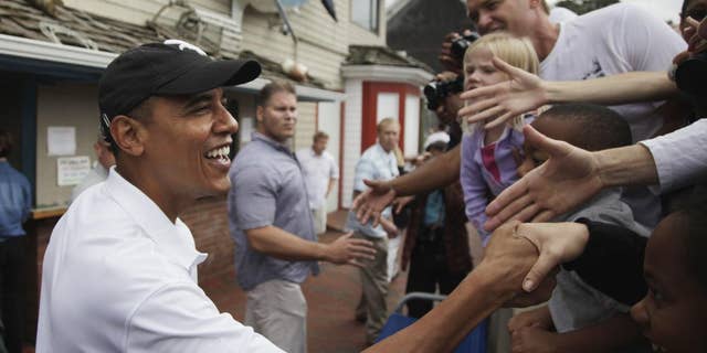 (AP File Photo Aug. 25, 2010) President Barack Obama greets people gathered outside Nancy's Restaurant in Oak Bluffs on Martha's Vineyard, Mass. He will vacation with his family in Martha's Vineyard at the end of this month as he's done in years past, the White House said Wednesday.