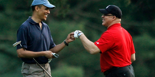 In this April 23, 2010 file photo, President Obama plays golf with Eric Whitaker at the Grove Park Inn Resort in Asheville, North Carolina.