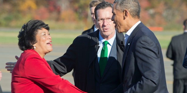 President Obama, right, is greeted by Gov. Dan Malloy, center, and New Haven Mayor Toni Harp, at Tweed New Haven Airport, in Connecticut.