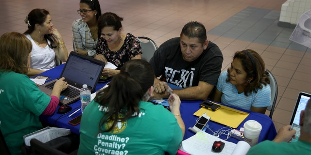 MIAMI, FL - DECEMBER 22: Rene Hernandez (2nd R) and his wife Nery Hernandez speak with Rosaly Hernandez an insurance agent with Sunshine Life and Health Advisors as they try to purchase health insurance under the Affordable Care Act at the kiosk setup at the Mall of Americas on December 22, 2013 in Miami, Florida.  Tomorrow is the deadline for people to sign up if they want their new health benefits to kick in on the 1st of January. People have until March 31, to sign up for coverage that would start later.  (Photo by Joe Raedle/Getty Images)