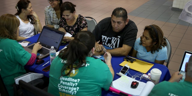 MIAMI, FL - DECEMBER 22: Rene Hernandez (2nd R) and his wife Nery Hernandez speak with Rosaly Hernandez an insurance agent with Sunshine Life and Health Advisors as they try to purchase health insurance under the Affordable Care Act at the kiosk setup at the Mall of Americas on December 22, 2013 in Miami, Florida. Tomorrow is the deadline for people to sign up if they want their new health benefits to kick in on the 1st of January. People have until March 31, to sign up for coverage that would start later. (Photo by Joe Raedle/Getty Images)