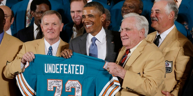 Former Miami Dolphins football quarterback Bob Griese, left, and Hall of Fame Dolphins Coach Don Shula, second from right, and Larry Csonka, right, pose for photographs with a signed team jersey during a ceremony in the East Room of the White House in Washington, Tuesday, Aug. 20, 2013, where the president honored the Super Bowl VII football Champion Miami Dolphins.