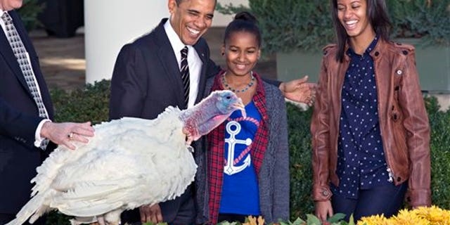 Nov. 21, 2012: President Obama, with daughters Sasha, center, and Malia, right, carries on the Thanksgiving tradition of saving a turkey from the dinner table with a "presidential pardon" at the White House.