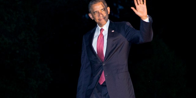June 6, 2014: President Barack Obama waves to the media as he returns at dusk on the South Lawn of the White House in Washington after attending remembrance activities on the 70th anniversary of D-Day in Normandy, France. (AP Photo/Jacquelyn Martin)
