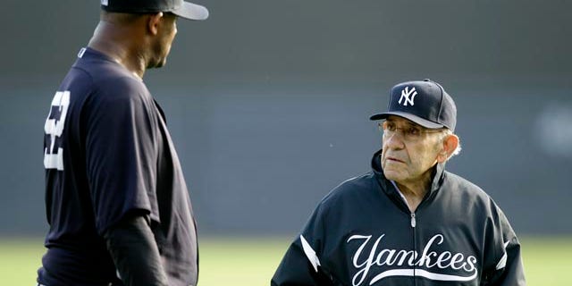 File-This Feb. 24, 2011, file photo shows New York Yankees pitcher CC Sabathia,left, talking with Yogi Berra, right, during a baseball spring training workout at Steinbrenner Field in Tampa, Fla. (AP Photo/Charlie Neibergall, File)