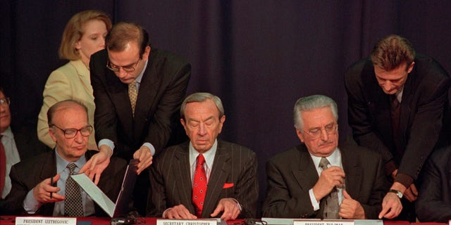 Then Secretary of State Warren Christopher, center, is flanked by Bosnia President Alija Izetbegovic, left, and Croatian President Franjo Tudjman as they sign the Dayton peace accord in this Nov. 10, 1995 file photo taken at Wright-Patterson Air Force Bae in Dayton, Ohio. (AP)