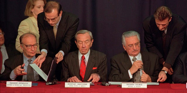 Then Secretary of State Warren Christopher, center, is flanked by Bosnia President Alija Izetbegovic, left, and Croatian President Franjo Tudjman as they sign the Dayton peace accord in this Nov. 10, 1995 file photo taken at Wright-Patterson Air Force Bae in Dayton, Ohio. (AP)