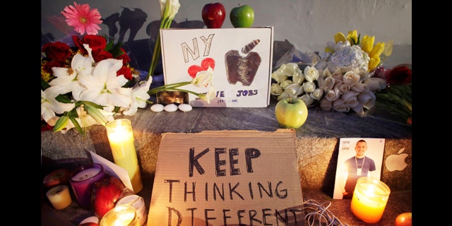 Candles illuminate a memorial to Apple co-founder Steve Jobs, Thursday, Oct. 6, 2011 in front of an Apple store in New York. Jobs died Wednesday at 56.