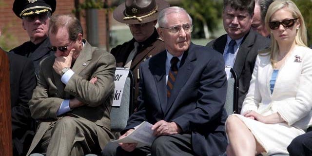 FILE - In this May 11, 2006, file photo, attending dignitaries including Oregon Gov. Ted Kulongoski, left, former Gov. Vic Atiyeh, center, and 2002 Miss America Katie Harmon sit, as the names of officers killed in the line of duty are read during the Oregon Law Enforcement Memorial ceremony at the new public-safety academy grounds in Salem, Ore. (AP Photo/Statesman-Journal, Thomas Patterson, File)
