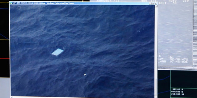 A photo taken off a computer monitor onboard a Royal New Zealand Air Force P-3 Orion, shows an object floating in an area within the search zone of the missing Malaysia Airlines Flight 370 in the Southern Indian Ocean off the coast of Western Australia, Friday, March 28, 2014. Australian Maritime Safety Authority has not confirmed any information about this object. Australian officials said that objects spotted floating in the search area need to be recovered and inspected before they can be linked to the plane. The objects, first spotted Friday, include two rectangular items that were blue and gray, and ships on the scene will attempt to recover them, the AMSA said. (AP Photo/Tony Cheng, Pool)