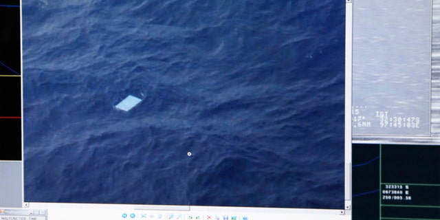 A photo taken off a computer monitor onboard a Royal New Zealand Air Force P-3 Orion, shows an object floating in an area within the search zone of the missing Malaysia Airlines Flight 370 in the Southern Indian Ocean off the coast of Western Australia, Friday, March 28, 2014. Australian Maritime Safety Authority has not confirmed any information about this object. Australian officials said that objects spotted floating in the search area need to be recovered and inspected before they can be linked to the plane. The objects, first spotted Friday, include two rectangular items that were blue and gray, and ships on the scene will attempt to recover them, the AMSA said. (AP Photo/Tony Cheng, Pool)