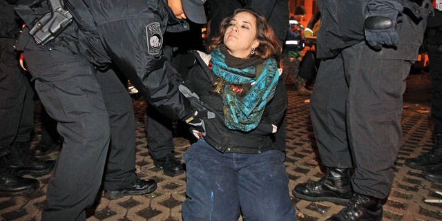 Dec. 10, 2011: Boston police officers remove an Occupy Boston protester from Dewey Square in Boston before dawn Saturday.