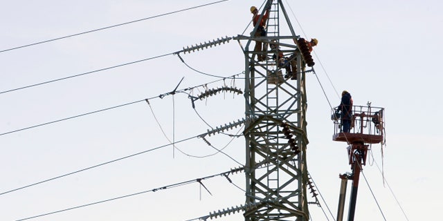 Connecticut Light & Power workers tend to a high voltage power line in Windsor Locks, Conn., Wednesday, Nov. 2, 2011. Over 90% of the town has been without power since the Oct. 29, 2011 snowstorm. (AP Photo/Jessica Hill)