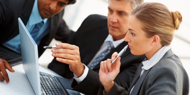 Team of business people working together on a laptop