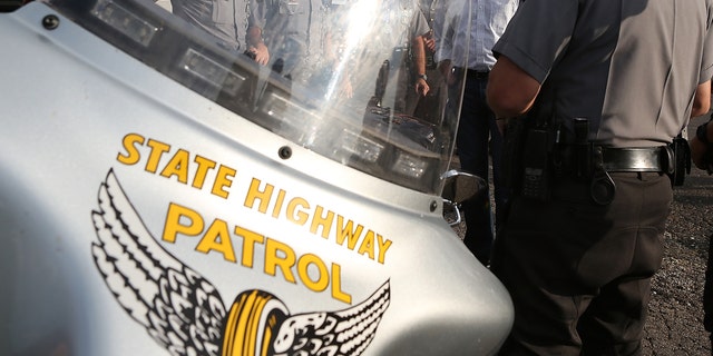 TARLTON, OH - AUGUST 14: Republican presidential candidate and former Massachusetts Governor Mitt Romney (C) meets Ohio State Highway Patrol officers in a church parking lot on August 14, 2012 in Tarlton, Ohio. Mitt Romney is wrapping up his multi state bus tour with campaign events in Ohio. (Photo by Justin Sullivan/Getty Images)