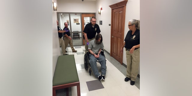 Officials transport Benjamin Robert Cole into a Pittsburg County courtroom, Friday, Aug. 28, 2015, in McAlester, Okla., before a hearing about his sanity. Cole is scheduled to die for killing his 9-month-old daughter in 2002. (AP Photo/Sean Murphy)