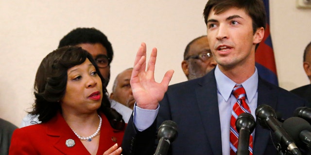 March 25, 2015: Oklahoma state Sen. Anastasia Pittman, left, D-Oklahoma City, stands with Levi Pettit, right, a former University of Oklahoma fraternity member caught on video leading a racist chant, during a news conference at Fairview Baptist Church in Oklahoma City. (AP Photo/Sue Ogrocki)