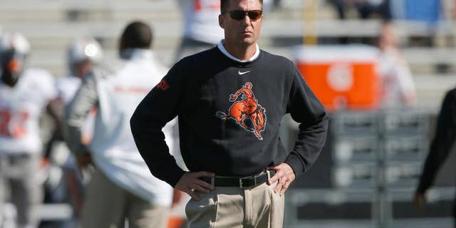 FILE - In this Oct. 11, 2014, file photo, Oklahoma State head coach Mike Gundy watches from the sideline before an NCAA college football game against Kansas in Lawrence, Kan. Gundy wasn't happy with the way his Cowboys played in a lackluster win over Kansas. No. 15 Oklahoma State had better fix their problems soon _ they play at No. 12 TCU on Saturday, Oct. 18. (AP Photo/Orlin Wagner, File)