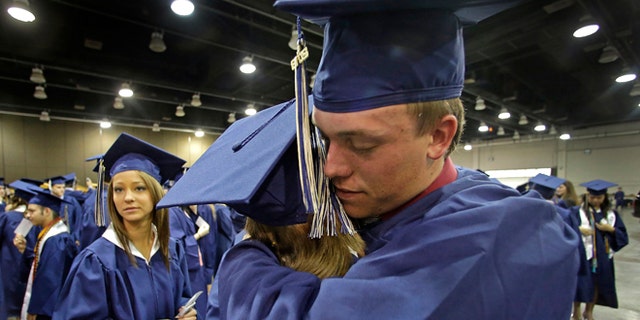 May 25, 2013: Southmoore High School senior Jake Spradling, hugs a classmate as they get ready to attend their commencement ceremony in Oklahoma City five days after a tornado destroyed a large swath of their attendance area in Moore, Okla.