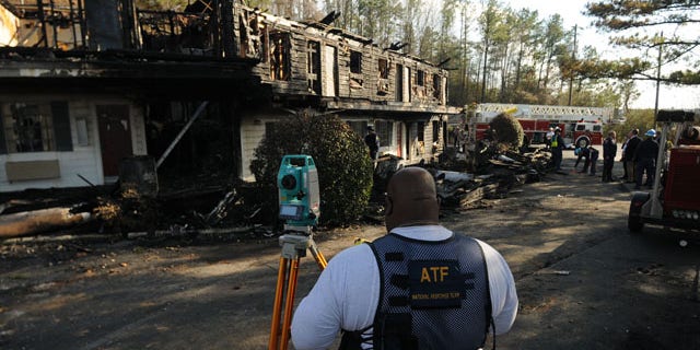 In this Jan. 18, 2010 photo, an investigator with the Bureau of Alcohol, Tobacco, Firearms and Explosives works at the site of a fatal fire which killed four Mississippi college students at the Days Inn in Hoover, Ala. (AP)