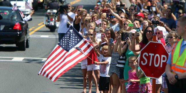People wave and hold flags during a parade for Olympic gymnast Laurie Hernandez on Saturday, Aug. 27, 2016, in Old Bridge, N.J. (Magdeline Bassett/The Asbury Park Press via AP)