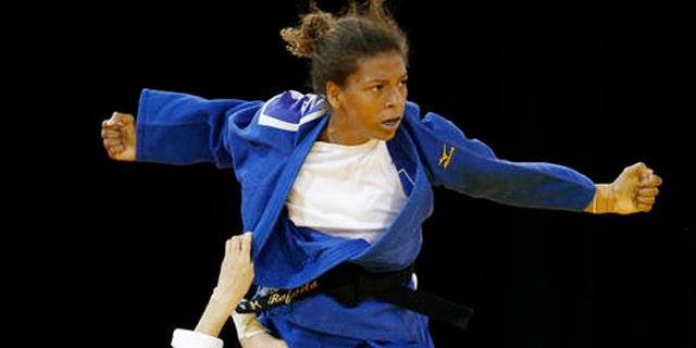FILE - In this July 12, 2015 file photo, Brazil's Rafaela Silva, top, competes against Venezuela's Anriquelis Barrios during a women's -57kg bronze medal judo match at the Pan Am Games, in Mississauga, Ontario. Silva hoped to get an Olympic gold medal four years ago in London. Disqualified in her Olympic judo match and eliminated from the chance of winning a medal, Brazils Silva thought shed find refuge in sympathetic text messages from fans in her country. Instead, heres what she found: The place for a monkey is in a cage. You are not an Olympian. (AP Photo/Julio Cortez, File)