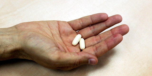 Nadav Kidron, CEO of Oramed Pharmaceuticals, holds insulin pills as he poses for a photo at the company's offices in Jerusalem September 29, 2013. (REUTERS/Baz Ratner)