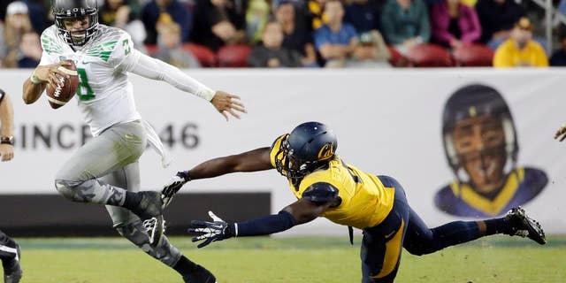 Oregon quarterback Marcus Mariota runs past California defensive end Jonathan Johnson during the second half of an NCAA college football game Friday, Oct. 24, 2014, in Santa Clara, Calif. (AP Photo/Marcio Jose Sanchez)