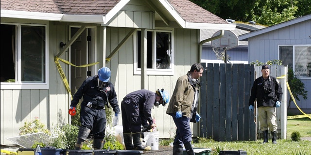 May 22, 2012: Investigators search in the front yard of a home where the bodies of the woman and children were discovered in Salem, Ore.