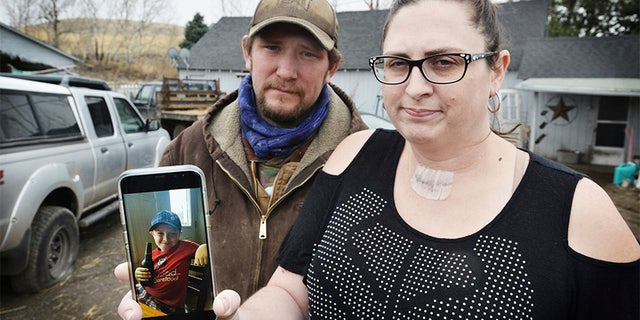 Scott Hinkle, left, and Sara Hebard, both of Pilot Rock, Oregon, lost their son, Liam Flanagan, 8, pictured in the cell phone photo, on Saturday, Jan. 21, 2018, after an eight-day battle with a flesh-eating bacteria. (E.J. Harris /East Oregonian via AP)