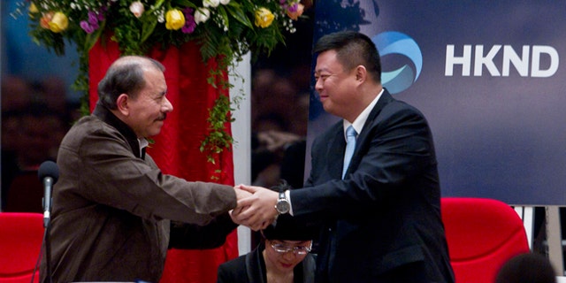 Nicaragua's President Daniel Ortega, left, and Chinese businessman Wang Jing shake hands before signing a concession agreement for the construction of a multibillion-dollar canal at the Casa de los Pueblos in Managua, Nicaragua, Friday, June 14, 2013.  Legislation approved by a 61-25 vote in the National Assembly dominated by Ortega's Sandinista Front contains no specific route for the canal and virtually no details of its financing or economic viability, but it grants a Hong Kong-based company 50 years of exclusive rights to study the plan and build and operate a canal in exchange for Nicaragua receiving a minority share of any profits. (AP Photo/Esteban Felix)