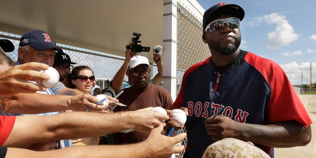 Boston Red Sox designated hitter David Ortiz signs autographs during spring training baseball practice, Sunday, Feb. 23, 2014, in Fort Myers, Fla. (AP Photo/Steven Senne)