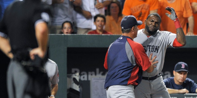 Boston Red Sox designated hitter David Ortiz reacts and is held back by manager John Farrell after being ejected by home plate umpire Tim Timmons for arguing a called third strike in the seventh inning of a baseball game against the Baltimore Orioles, Saturday, July 27, 2013, in Baltimore. Boston won 7-3. (AP Photo/Gail Burton)