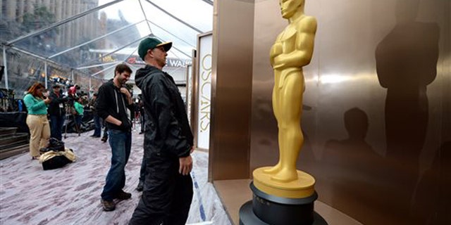 Preparations continue on the red carpet during rainy weather for the 86th Academy Awards in Los Angeles, Friday, Feb. 28, 2014. The Academy Awards will be held at the Dolby Theatre on Sunday, March 2. (Photo by Jordan Strauss/Invision/AP)