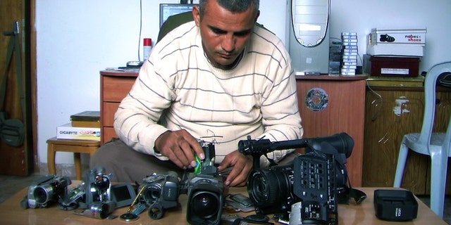 This undated publicity photo released by Kino Lorber, Inc. shows Co-director Emad Burnat with his five broken cameras.