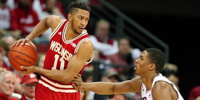 Wisconsin Badgers guard Jordan Hill looks to pass as Illinois guard Malcolm Hill defends during the first half at the Kohl Center in Madison, Wis., on Sunday, Feb. 21, 2016.