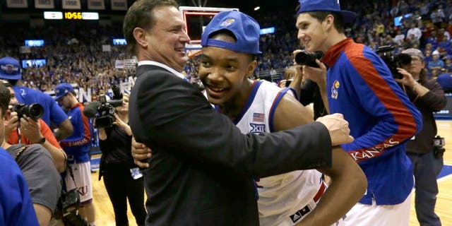 Kansas coach Bill Self, left, hugs guard Devonte Graham following an NCAA college basketball game against West Virginia at Allen Fieldhouse in Lawrence, Kan., Tuesday, March 3, 2015. Kansas defeated West Virginia 76-69 in overtime. (AP Photo/Orlin Wagner)