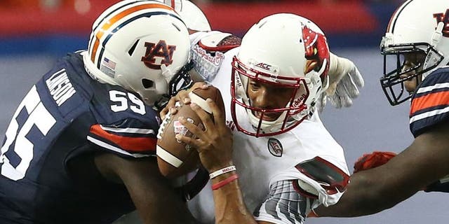 Auburn defensive lineman Carl Lawson (55) tackles Louisville quarterback Reggie Bonnafon (7) during the first half of an NCAA college football game, Saturday, Sept. 5, 2015, in Atlanta. (AP Photo/John Bazemore)