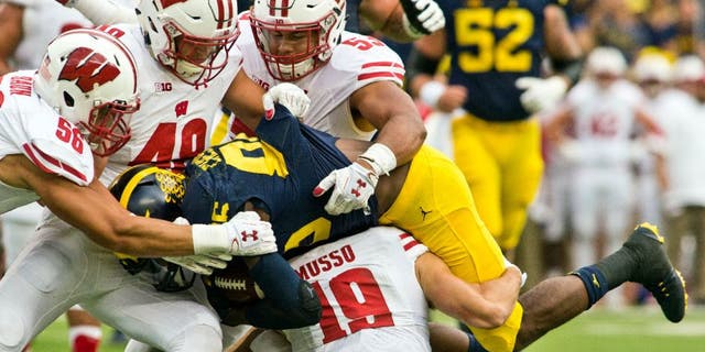 Michigan wide receiver Jehu Chesson, center, is gang-tackled by Wisconsin defenders Zack Baun, Jack Cichy, T.J. Edwards and Leo Musso in the first quarter.