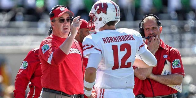 Wisconsin Badgers head coach Paul Chryst talks to quarterback Alex Hornibrook during a time out during the first half of a game against the Michigan State Spartans at Spartan Stadium in East Lansing, Mich., on Sept. 24, 2016.