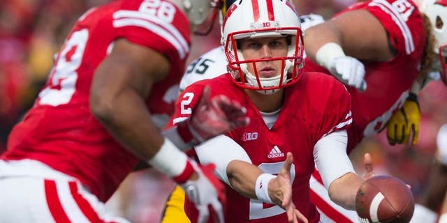 Wisconsin Badgers quarterback Joel Stave pitches the football to running back Taiwan Deal during the first quarter against the Iowa Hawkeyes at Camp Randall Stadium in Madison, Wis., on Saturday, Oct. 3, 2015.