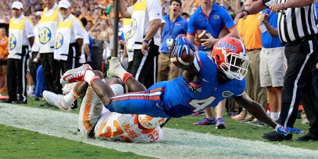 Sep 26, 2015; Gainesville, FL, USA; Florida Gators wide receiver Brandon Powell (4) runs the ball in for a touchdown as Tennessee Volunteers defensive back LaDarrell McNeil (33) attempts to defend during the second half at Ben Hill Griffin Stadium. Florida Gators defeated the Tennessee Volunteers 28-27. Mandatory Credit: Kim Klement-USA TODAY Sports