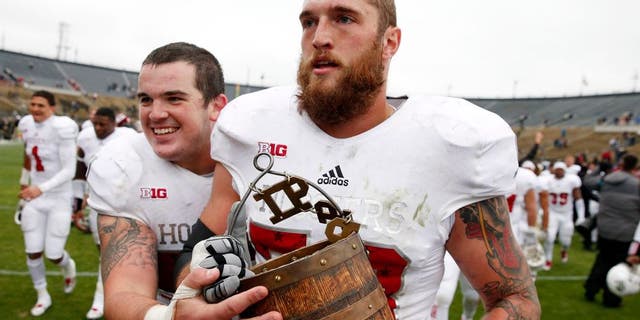 Nov 28, 2015; West Lafayette, IN, USA; Indiana Hoosiers center Jake Reed (50) and offensive tackle Jason Spriggs (78) walk off the field carrying the Old Oaken Bucket after the victory against the Purdue Boilermakers at Ross Ade Stadium. Indiana defeats Purdue 54-36. Mandatory Credit: Brian Spurlock-USA TODAY Sports