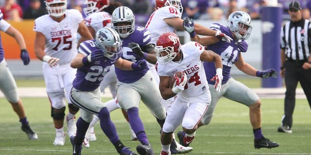 Oct 17, 2015; Manhattan, KS, USA; Oklahoma Sooners running back Daniel Brooks (34) is chased by Kansas State Wildcats defensive back Sean Newlan (29) during the Sooners 55-0 win at Bill Snyder Family Football Stadium. Mandatory Credit: Scott Sewell-USA TODAY Sports